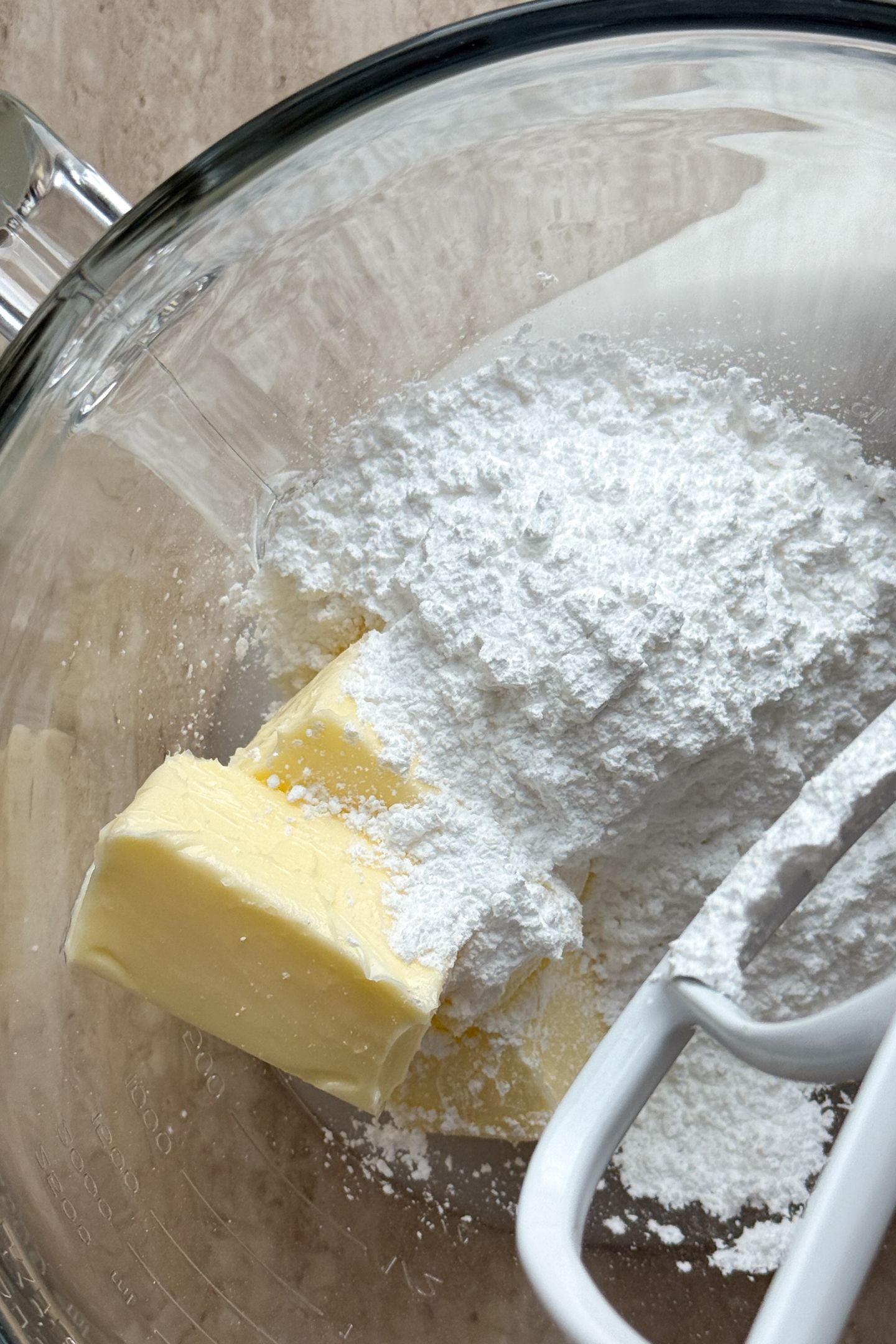 Softened butter and powdered sugar in the bowl of a stand mixer.