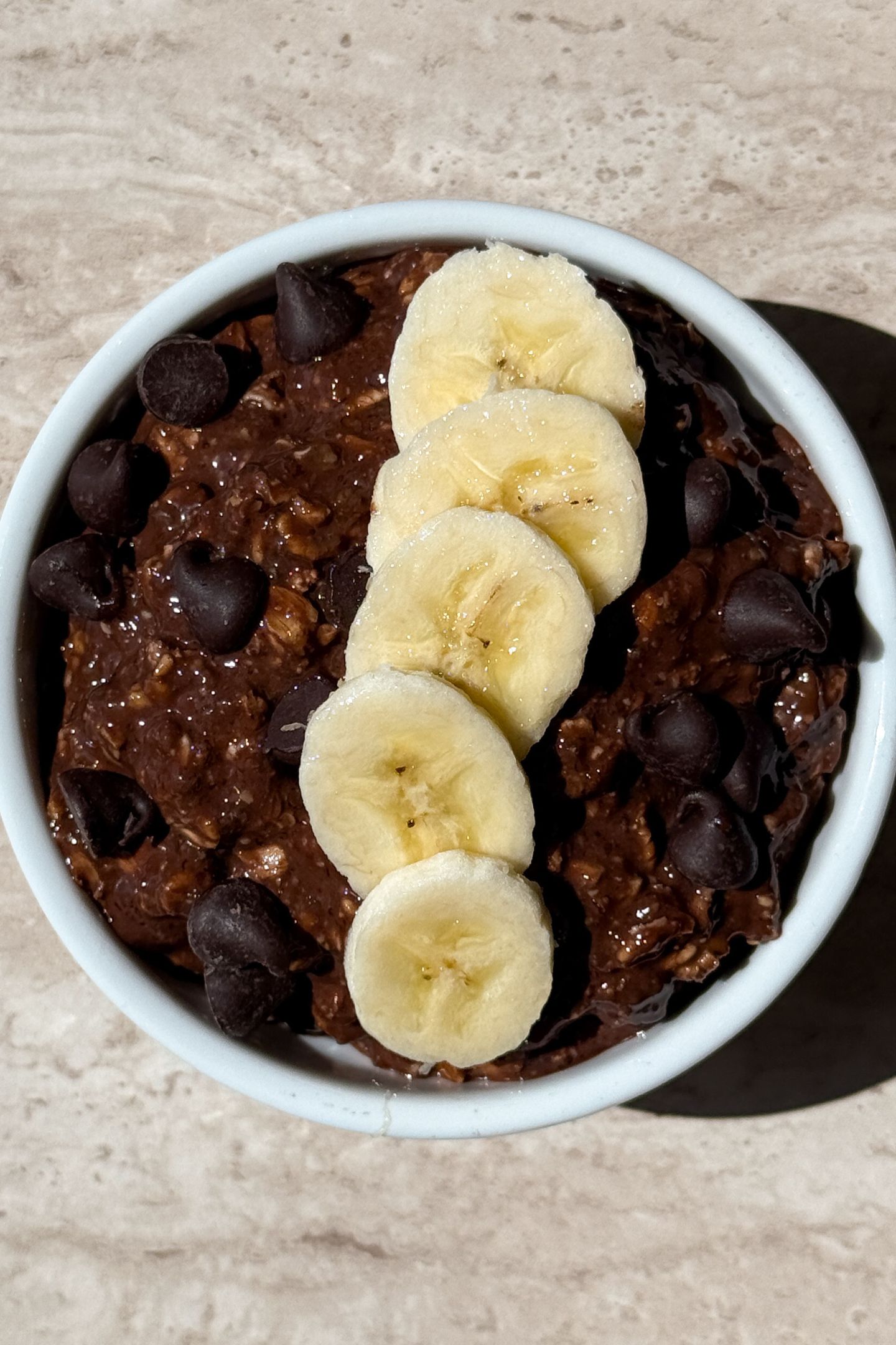 Chocolate banana overnight oats topped with banana slices.