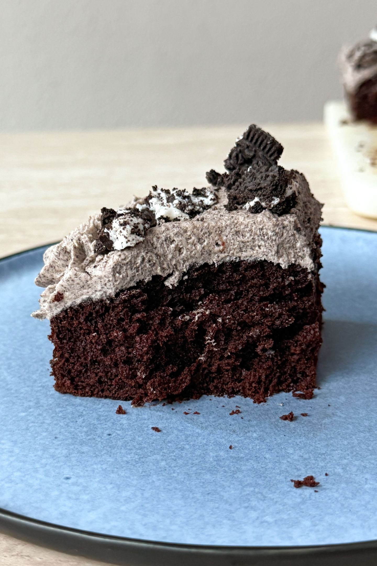 A side view of a slice of the cookies and cream cake on a plate.