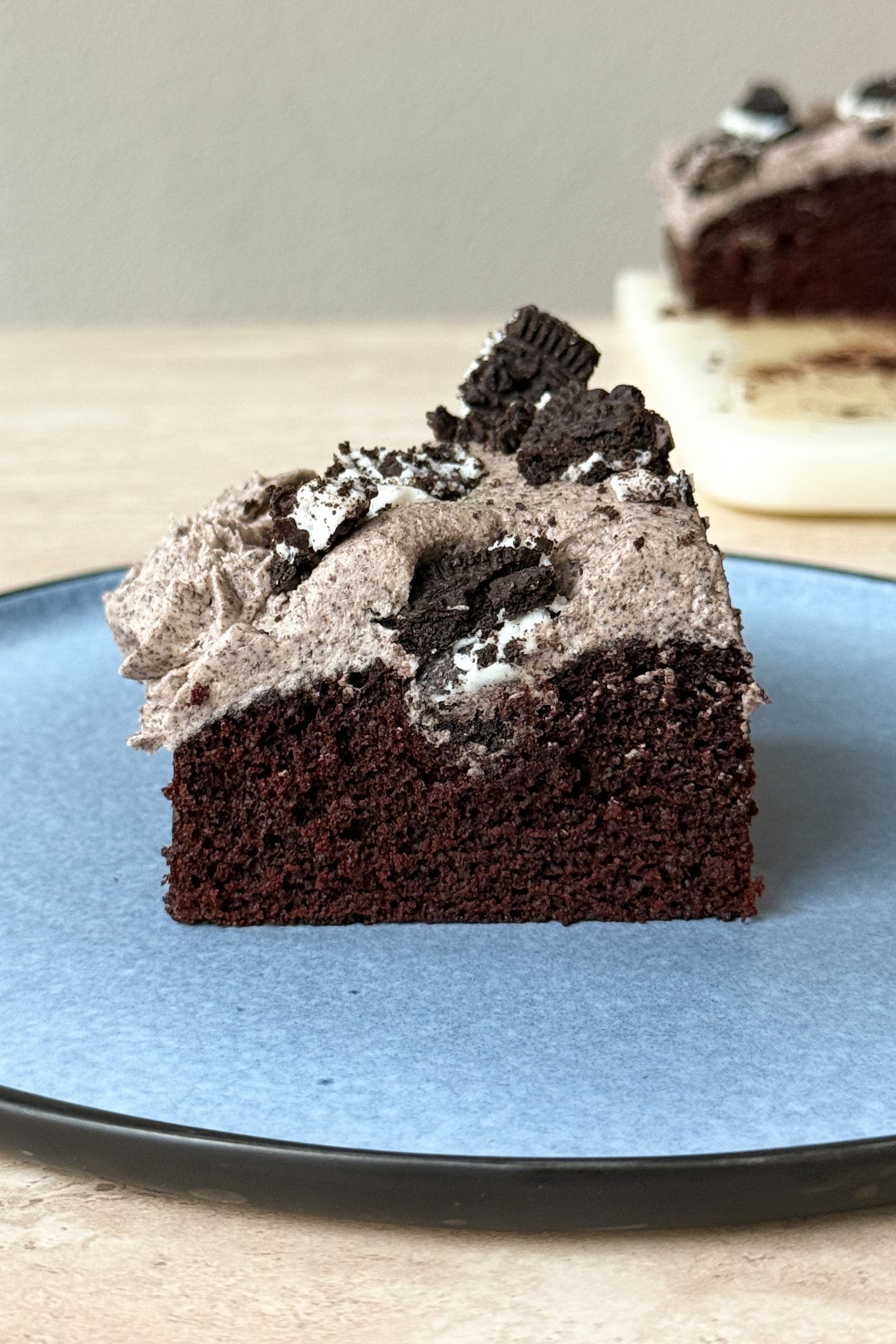 A side view of a slice of the cookies and cream cake on a plate.