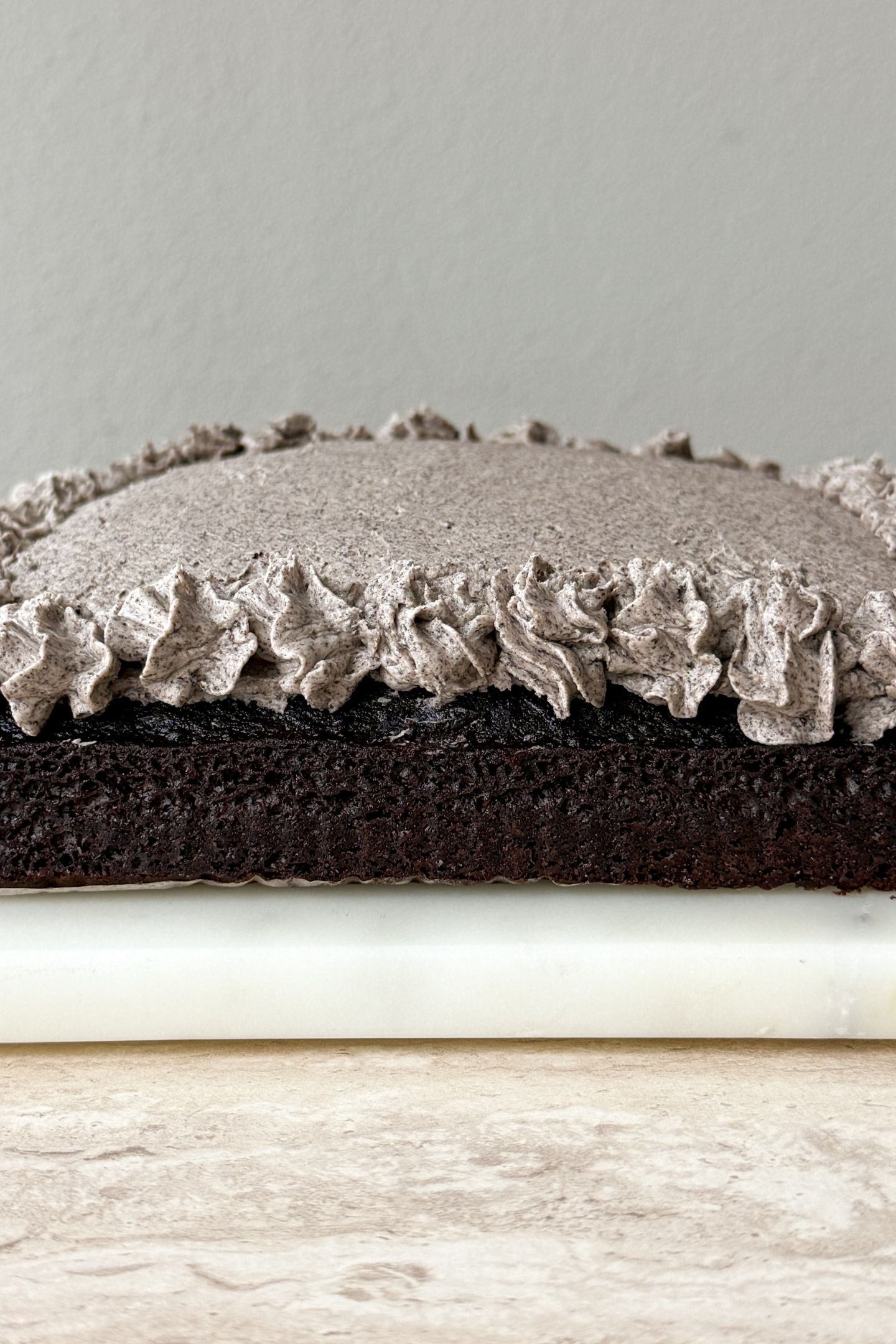 Decorating the cookies and cream frosting on top of the chocolate cake.