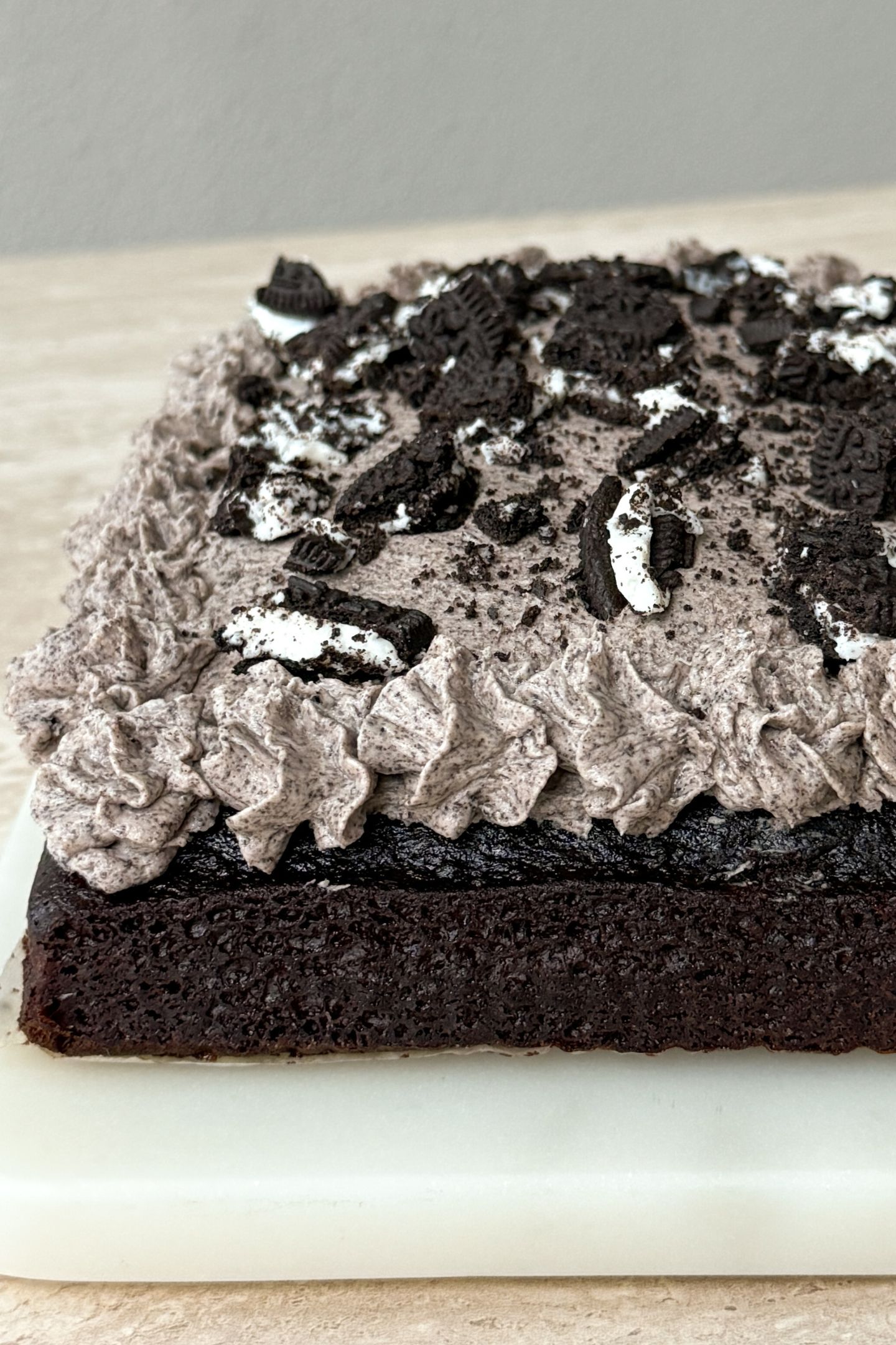 The cookies and cream frosting on top of the chocolate cake along with crushed cookies.