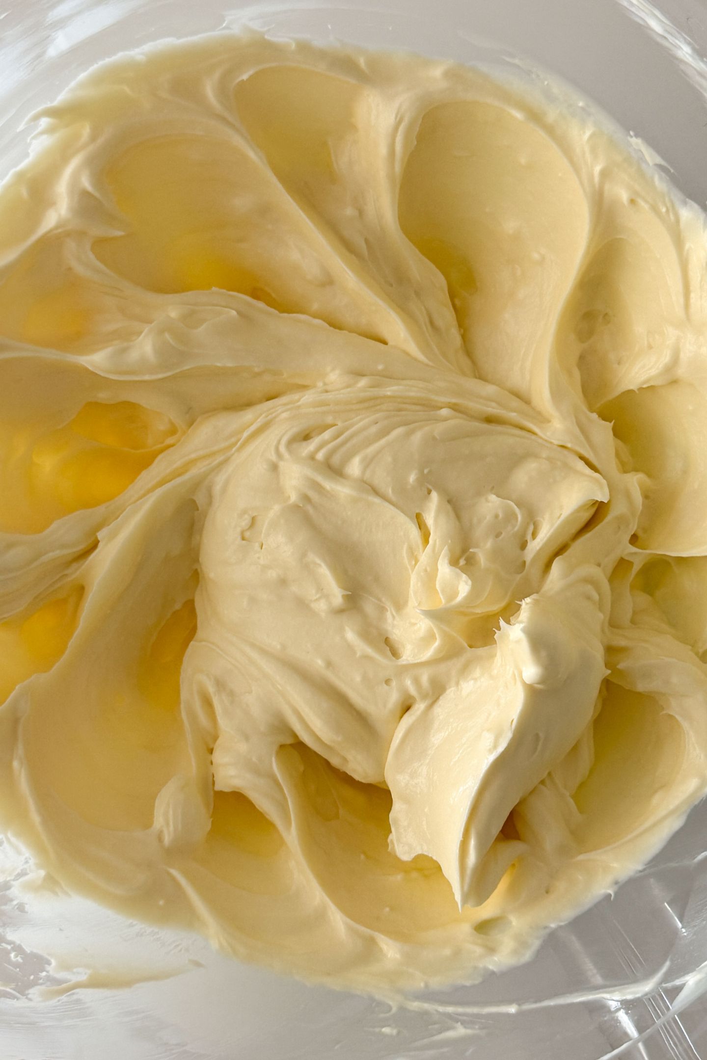 Butter, cream cheese, vanilla extract and an egg mixed together in a mixing bowl.