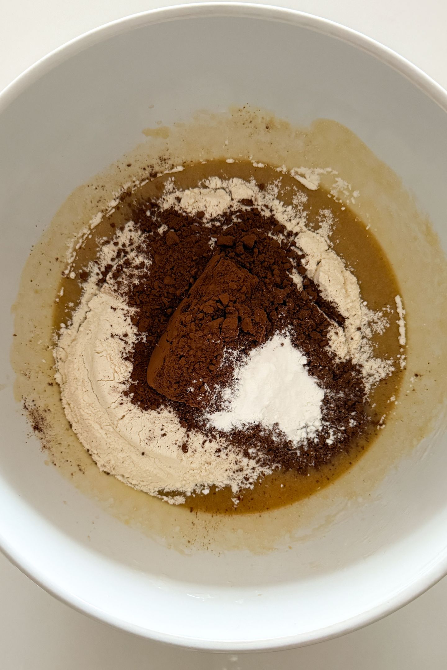 Adding the dry ingredients to the wet ingredients in a mixing bowl.