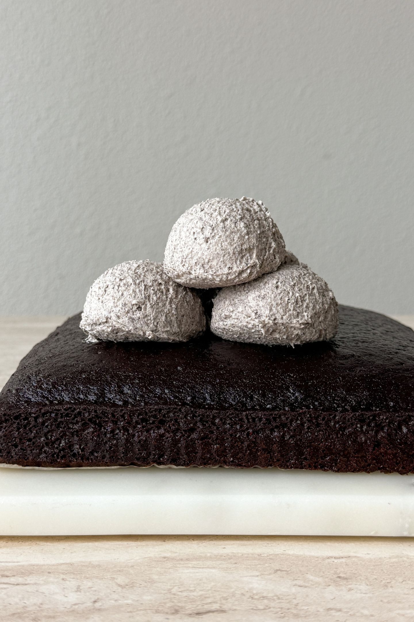 Topping the cake with the cookies and cream frosting.