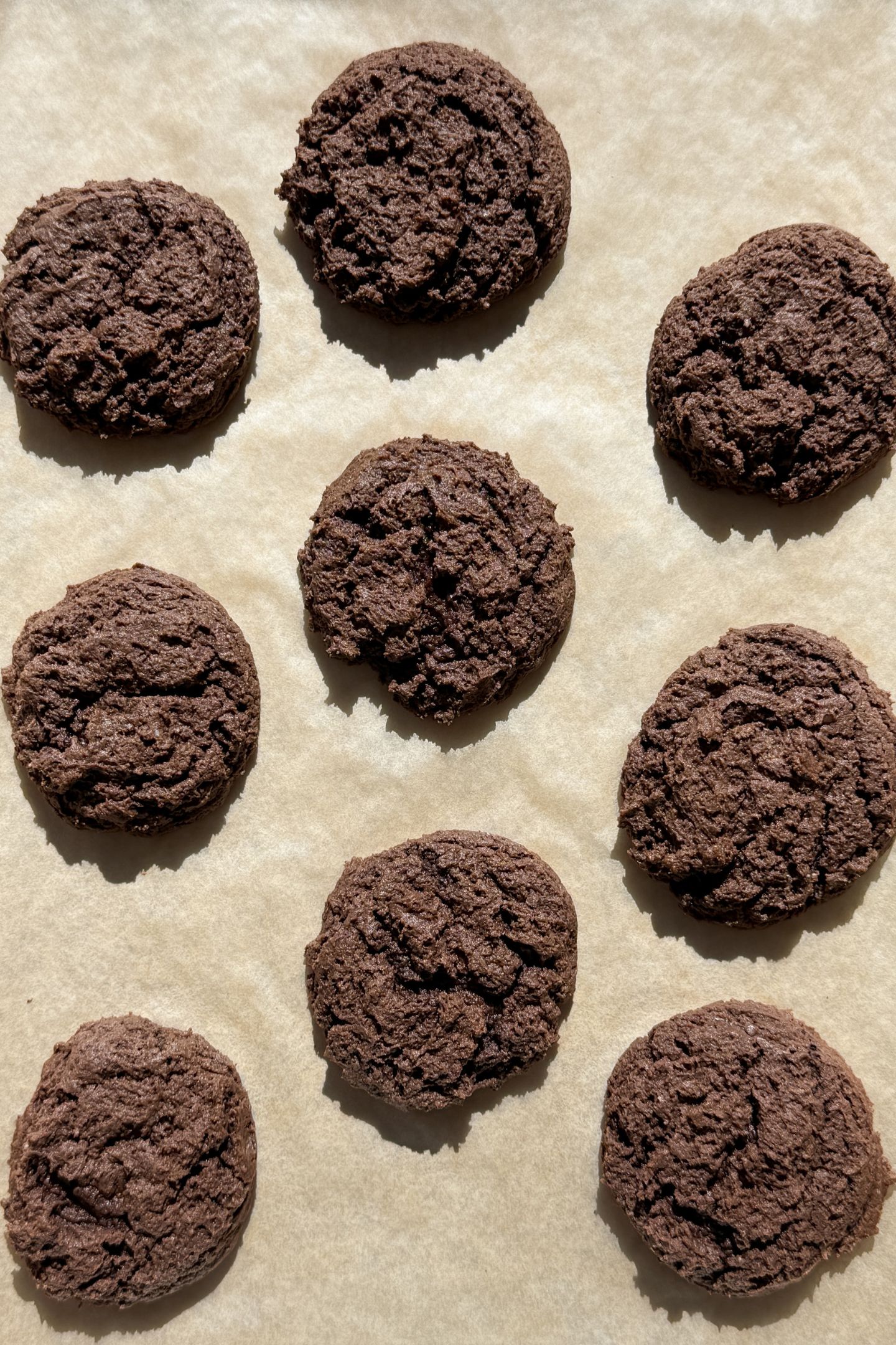 Baked cookies on a baking sheet lined with parchment paper.