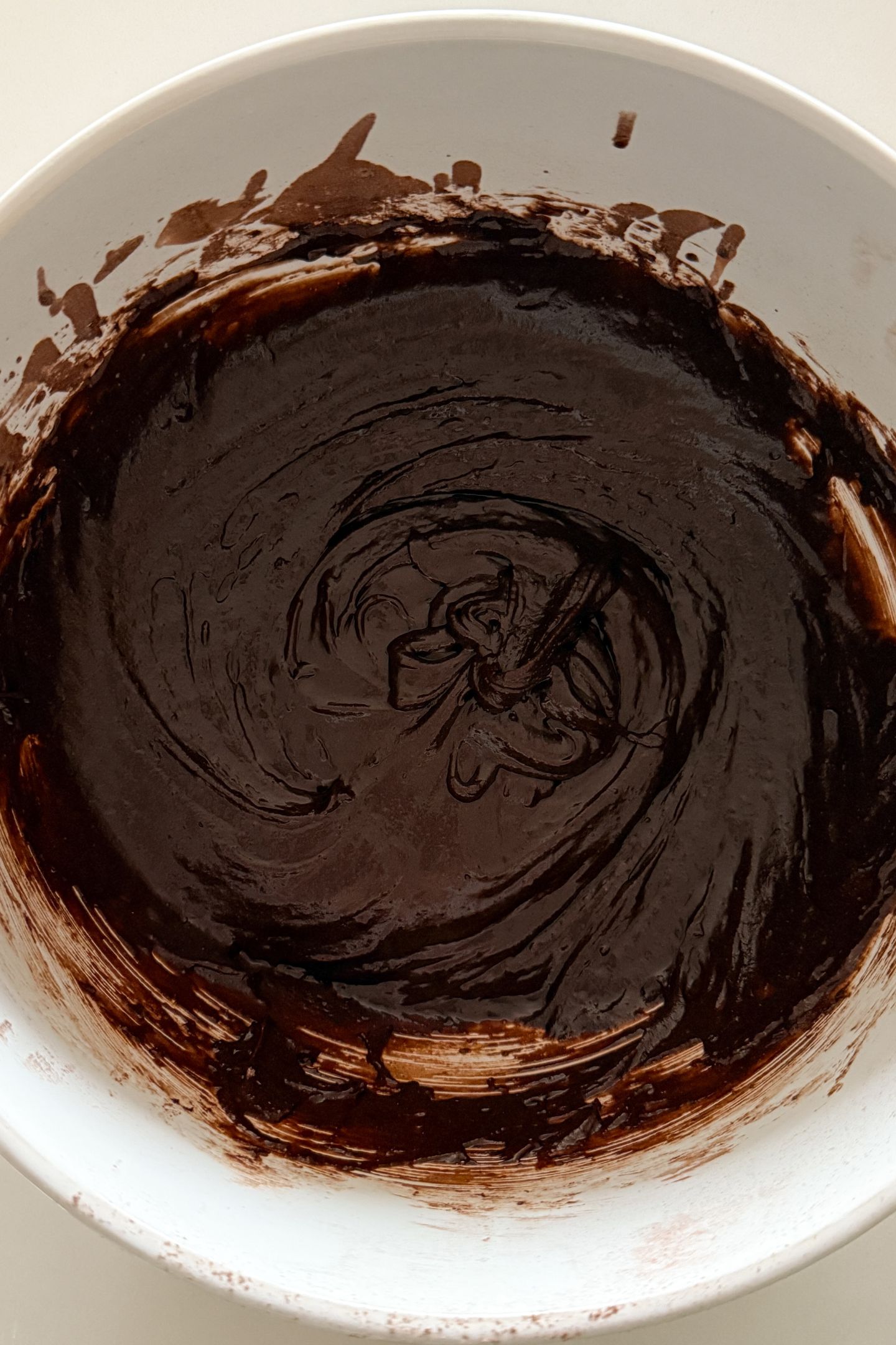 Wet and dry ingredients combined together in a mixing bowl.