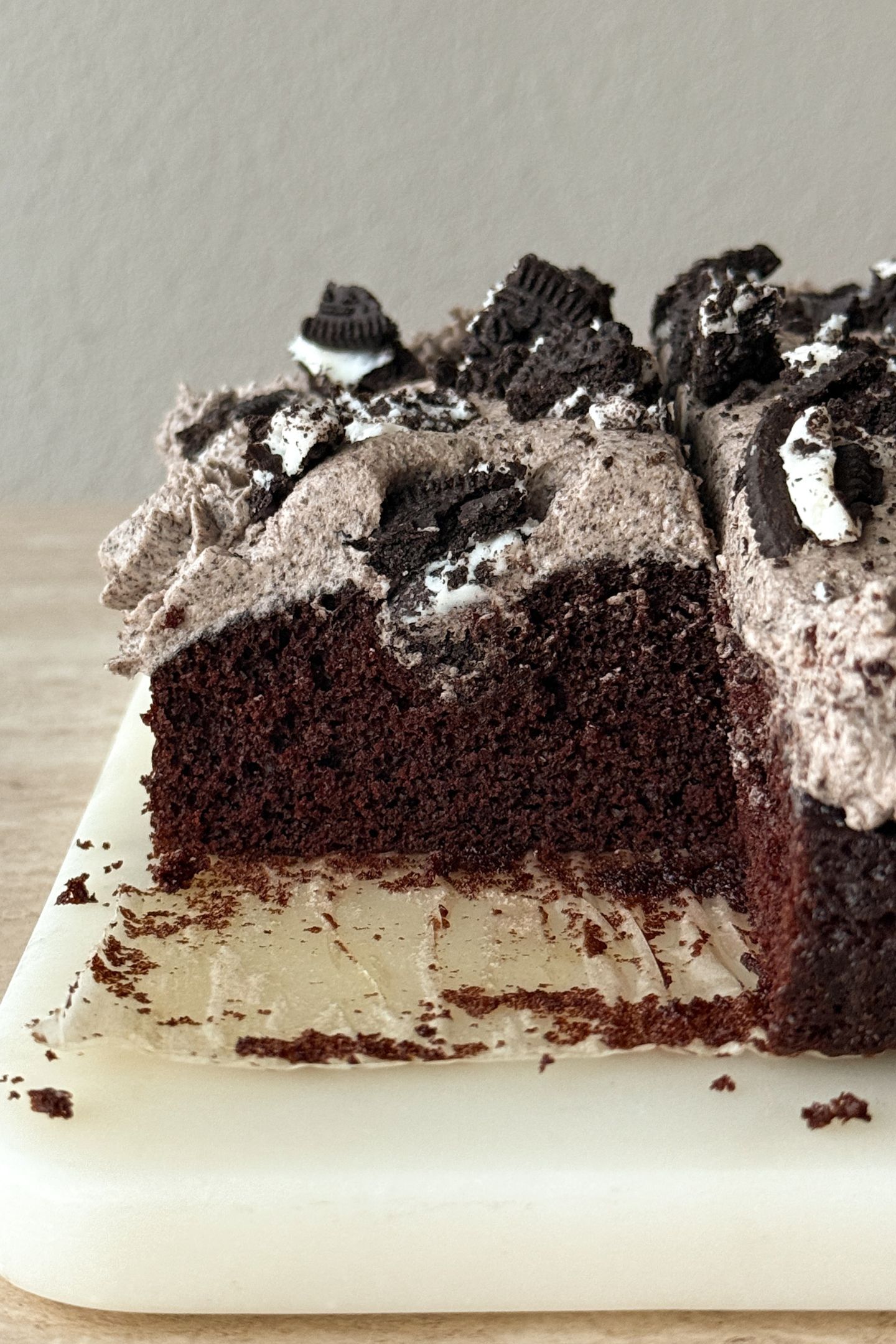 Slicing the cookies and cream cake on a platter.