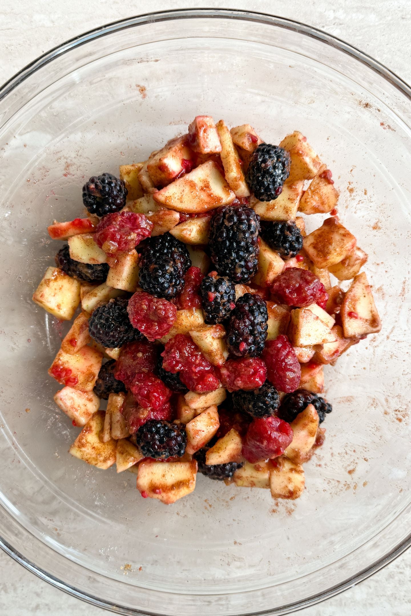 Apple and berry filling mixed together in a mixing bowl.