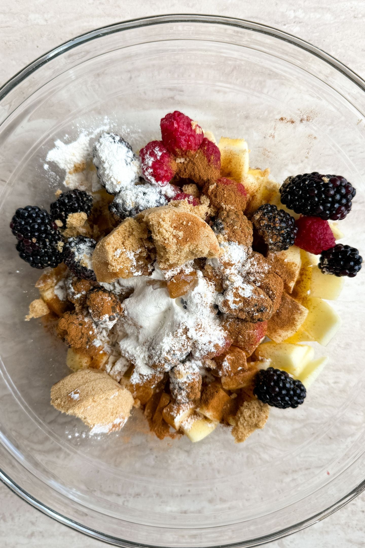 Brown sugar, cinnamon and flour add to the bowl with the mixed berries and apple slices.