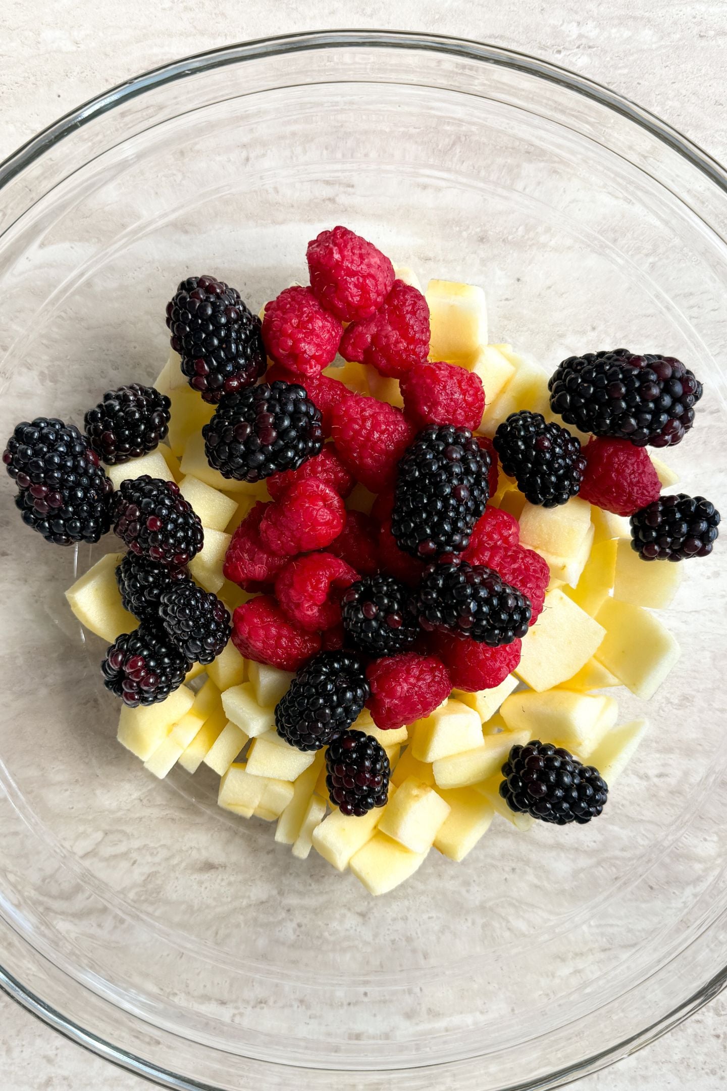 Berries and apples in a bowl.