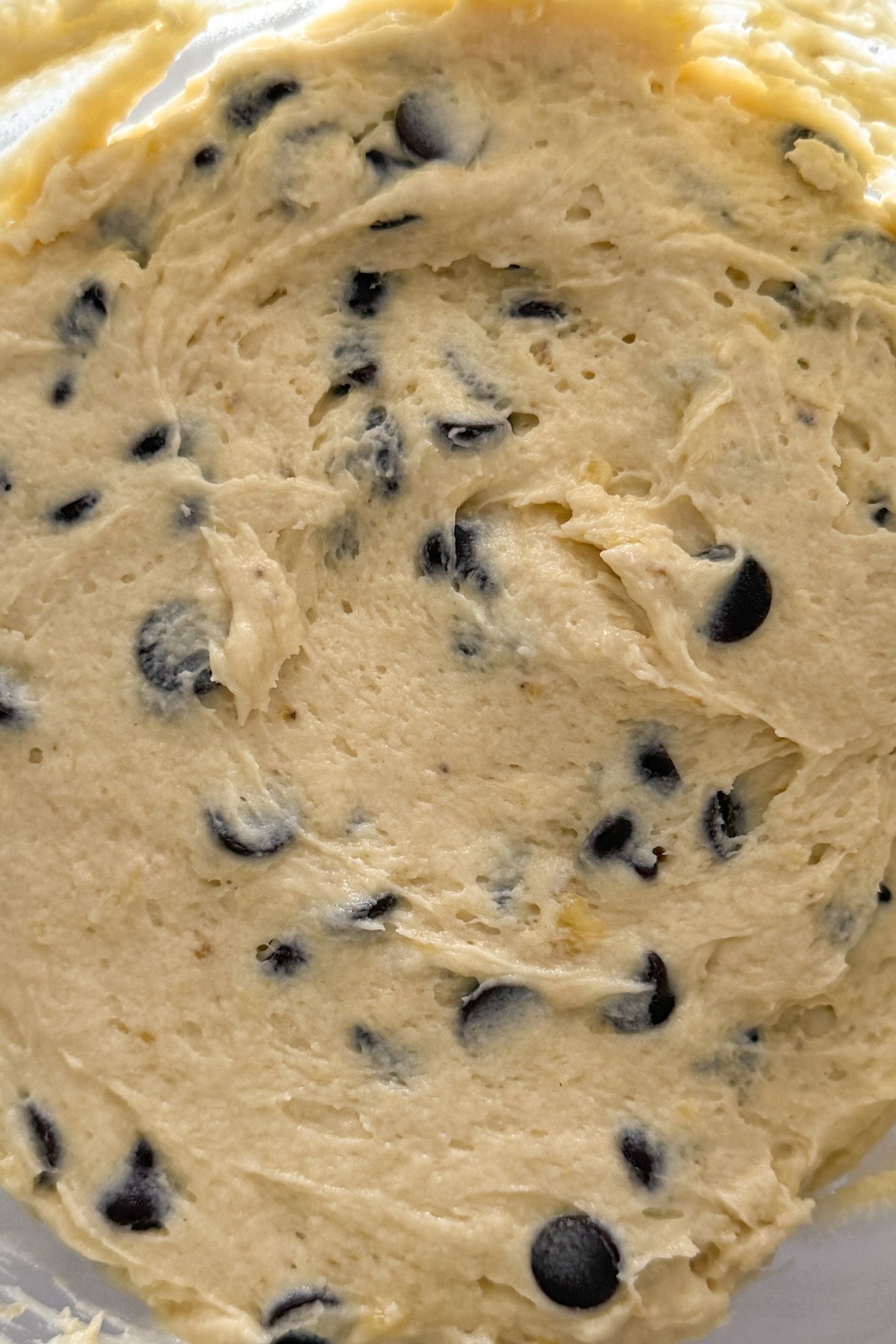 Chocolate chips added to the batter in the mixing bowl.
