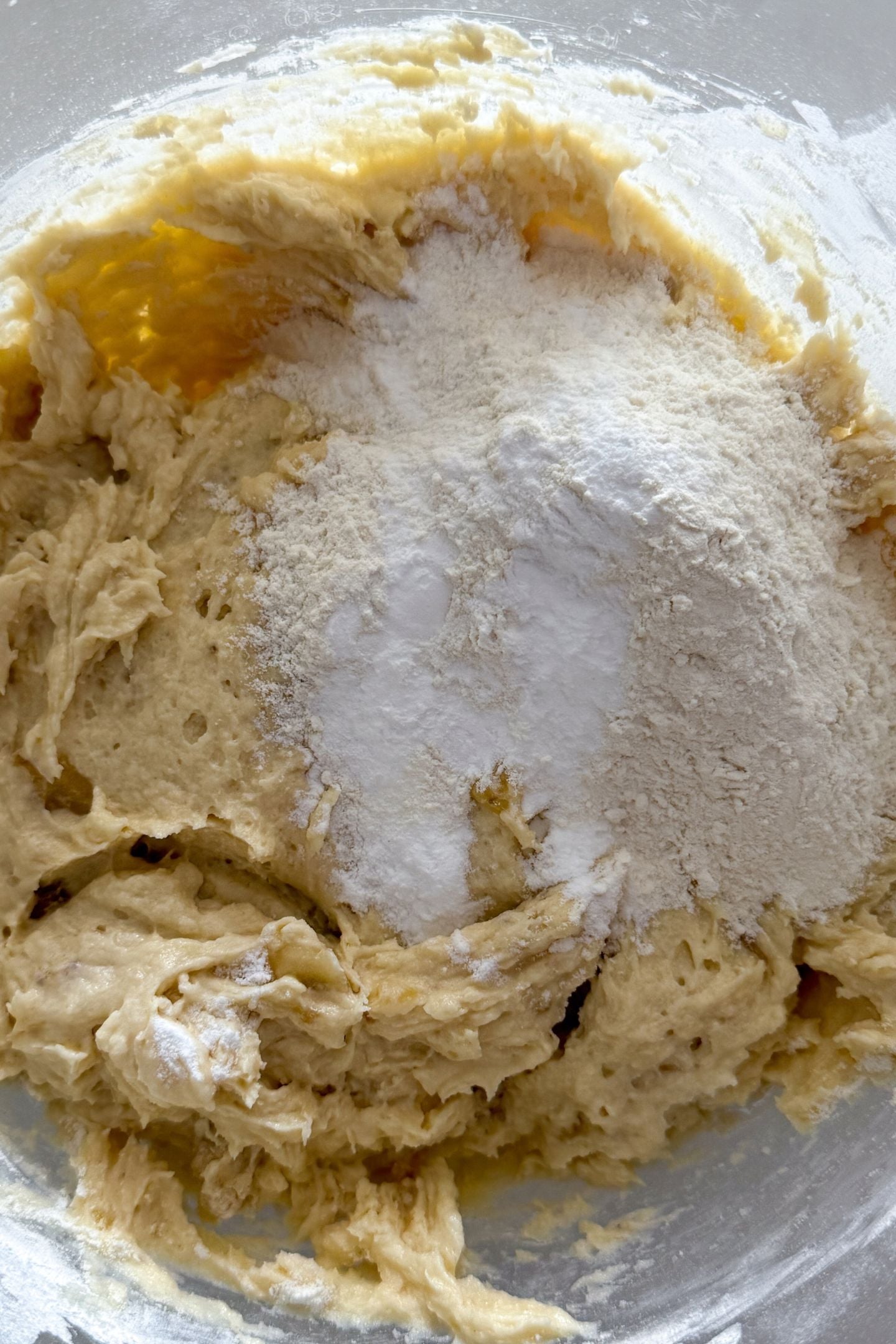Adding the remaining flour to the cake batter.