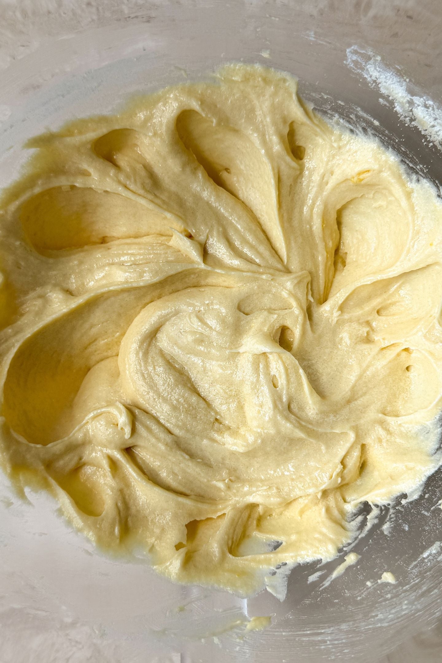 The half of the flour mixed into the wet ingredients in the mixing bowl.