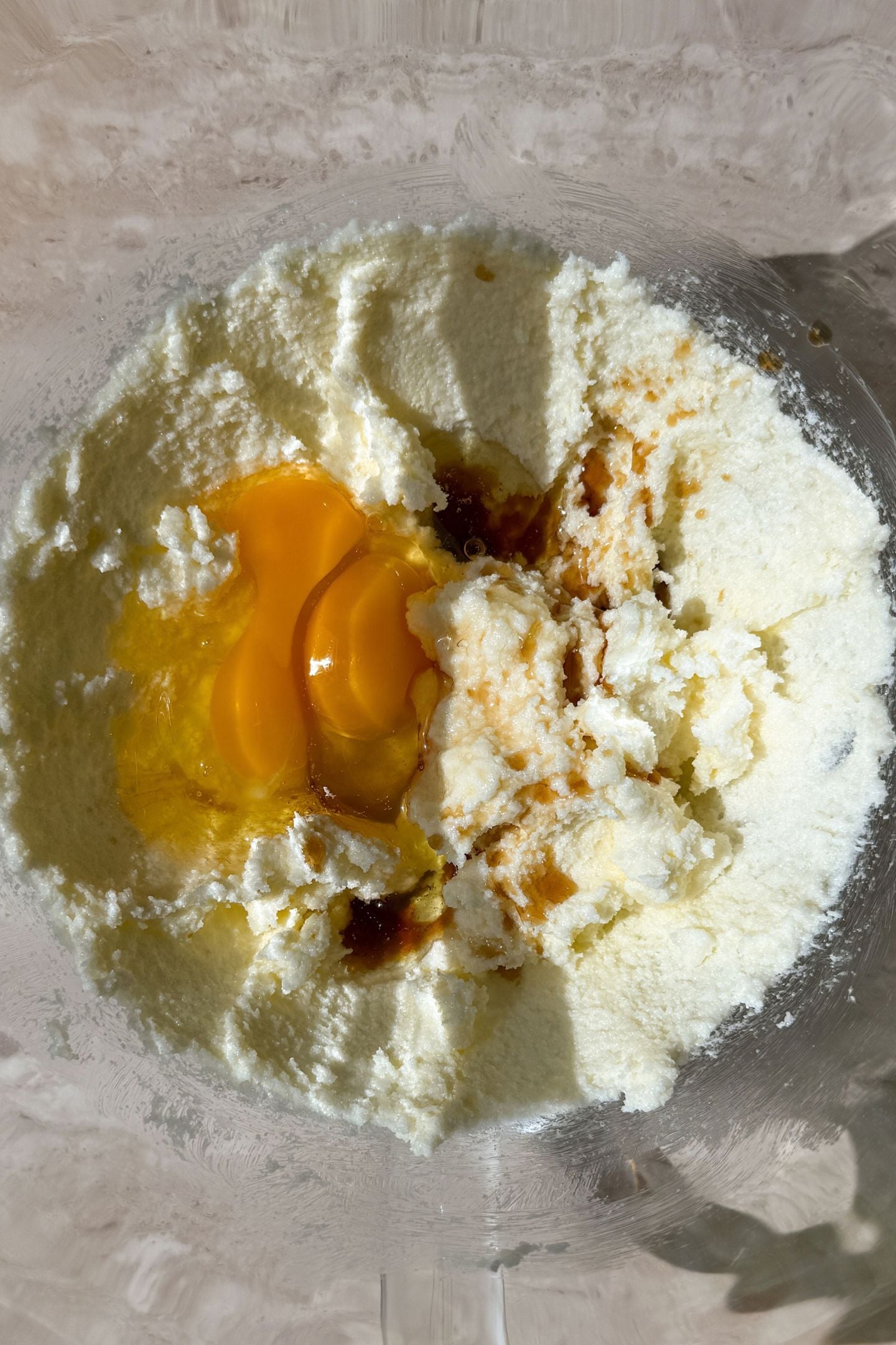Adding the remaining wet ingredients to the creamed butter and sugar in the mixing bowl.