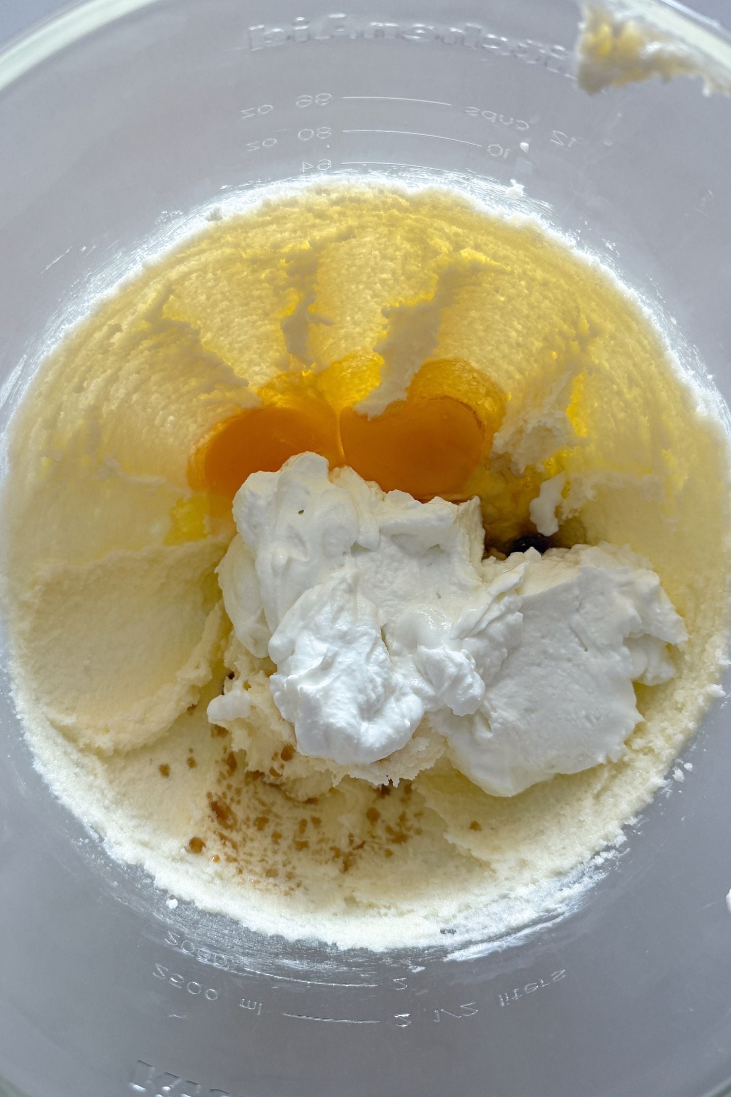 Adding the remaining wet ingredients to the creamed butter and sugar in the stand mixer.