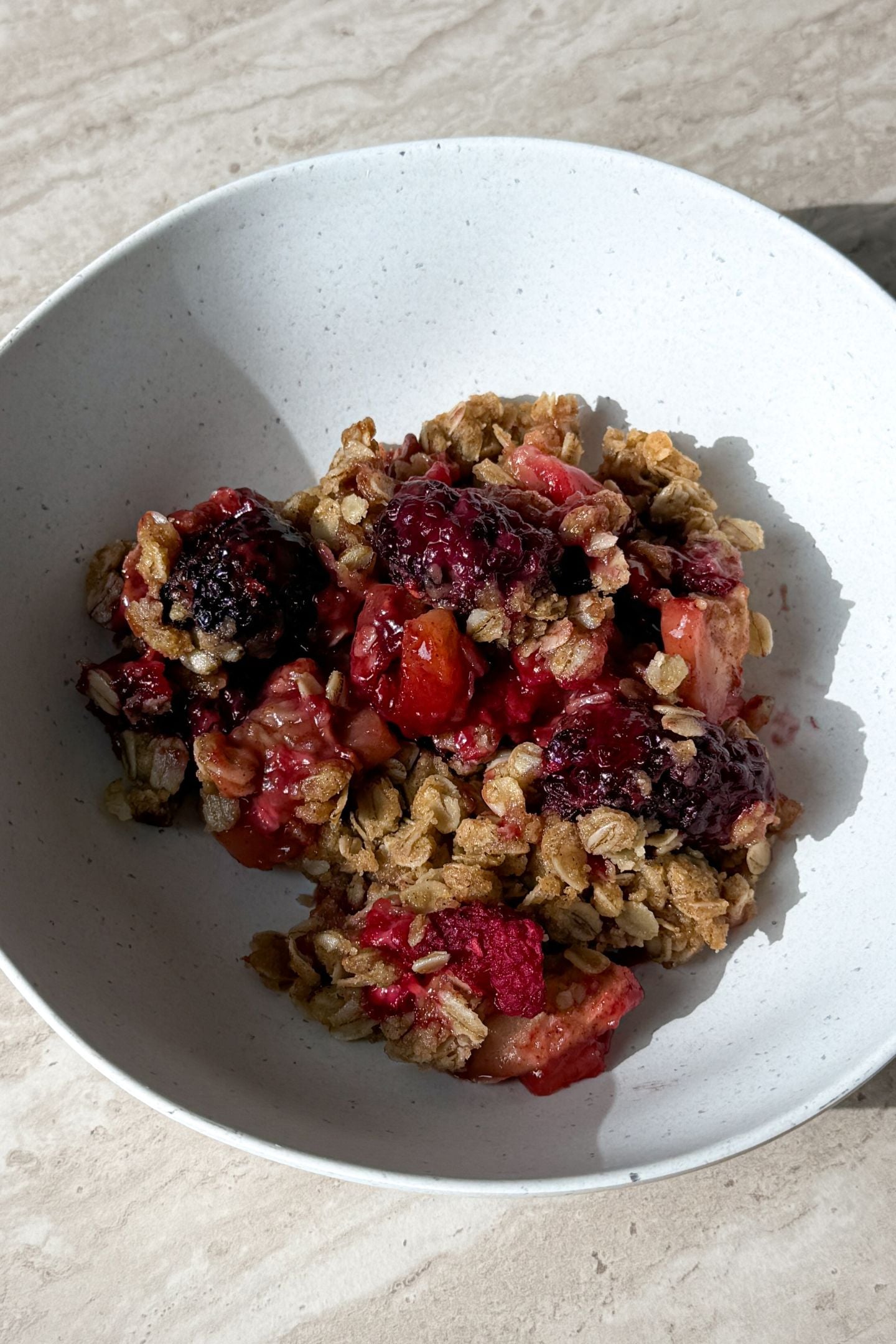 Scooping the berry apple crisp into a bowl.