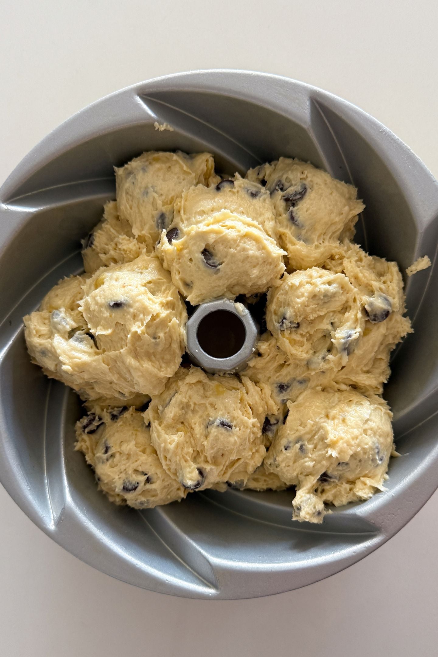 Transferring the cake batter to the prepared bundt cake pan.